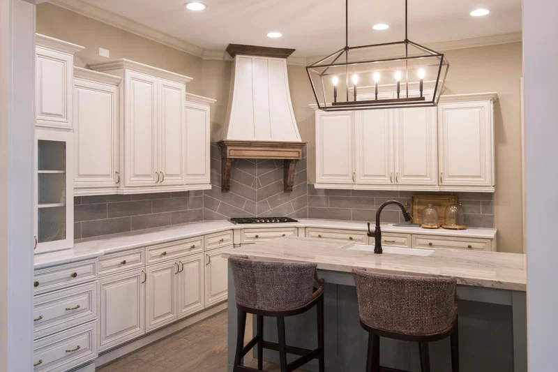 White kitchen cabinetry, a countertop and patterned tile backsplash